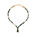 A beaded necklace featuring dark green rectangular beads, small gold spacer beads, a white accent bead, and a dark green teardrop pendant, displayed on a solid white background.